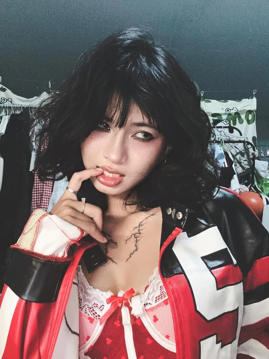Close portrait of Hoàng Anh in a red, black, and white racing jacket