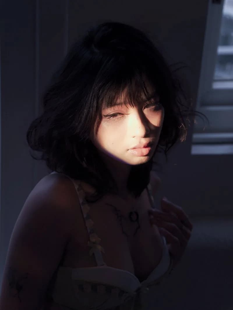 Close portrait of Hoàng Anh, a stripe of light across her face